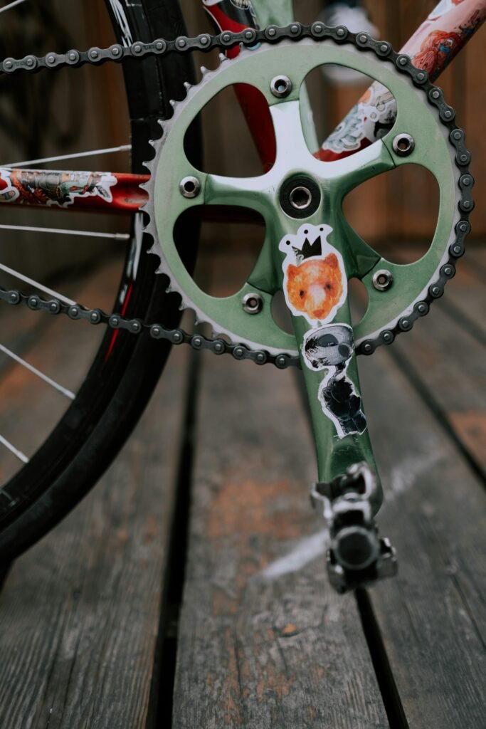 Close-up view of a bicycle crankset featuring colorful animal stickers.
